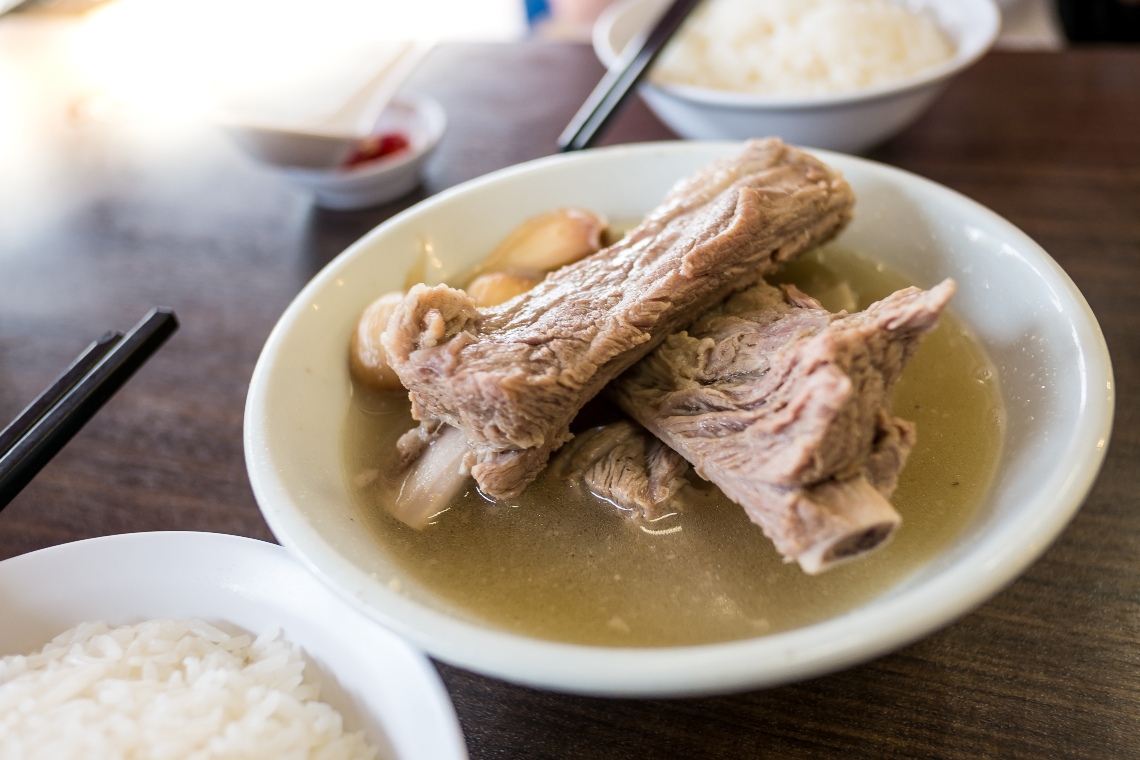 A bowl of Bak Kut Teh served with a bowl of white rice.